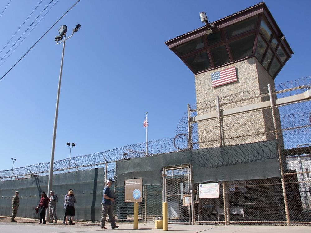 People walk past a guard tower outside the fencing of Camp 5 at the the U.S. military's prison in Guantánamo Bay, Cuba, on Jan. 26, 2017.