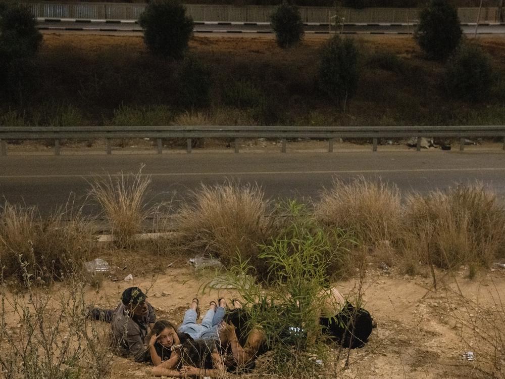 Israelis shelter along a highway during a missile barrage from Iran on Oct. 1. <a href=