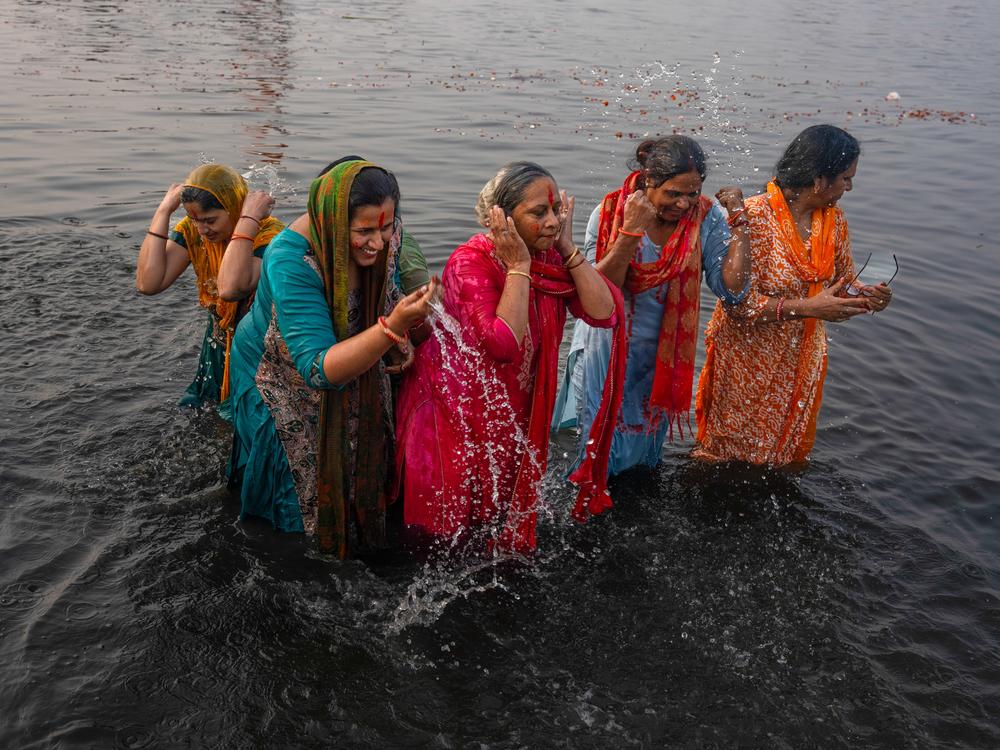Women wash themselves in the waters of the Yamuna river, which are considered holy by Hindus.