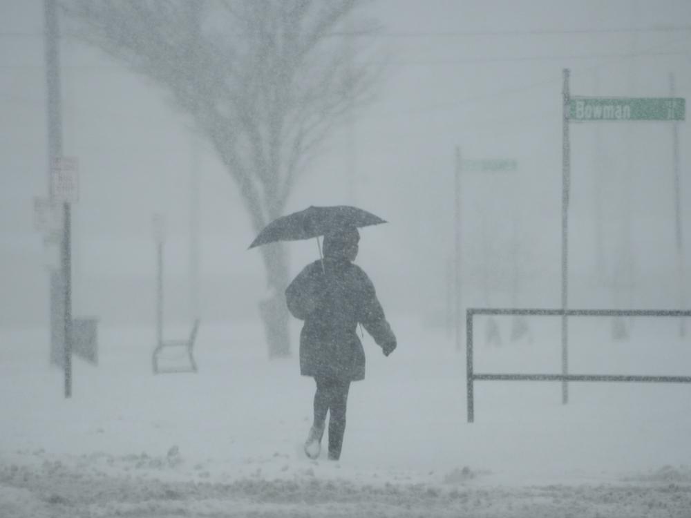 A person holds an umbrella as they walk during a winter storm, Monday, Jan. 6, 2025, in Cincinnati.