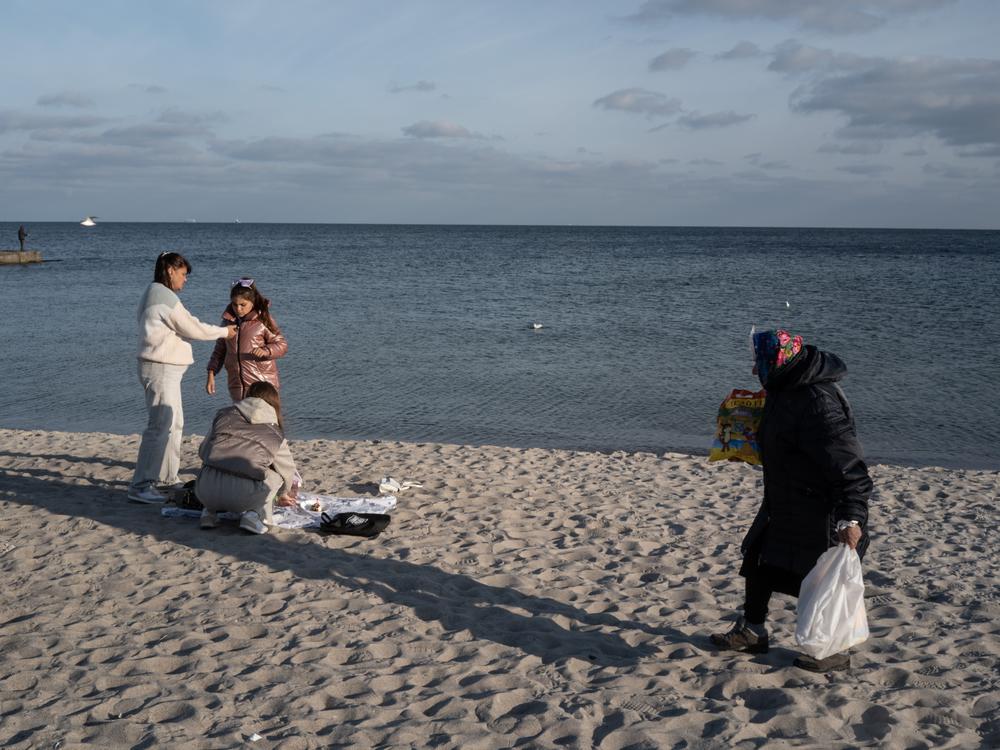 People enjoy a mild fall afternoon on a Black Sea beach in Odesa, Ukraine, on Oct. 27, 2024. The region comes under frequent aerial attack by Russians who launch missiles from the nearby Crimean Peninsula and ships in the Black Sea.