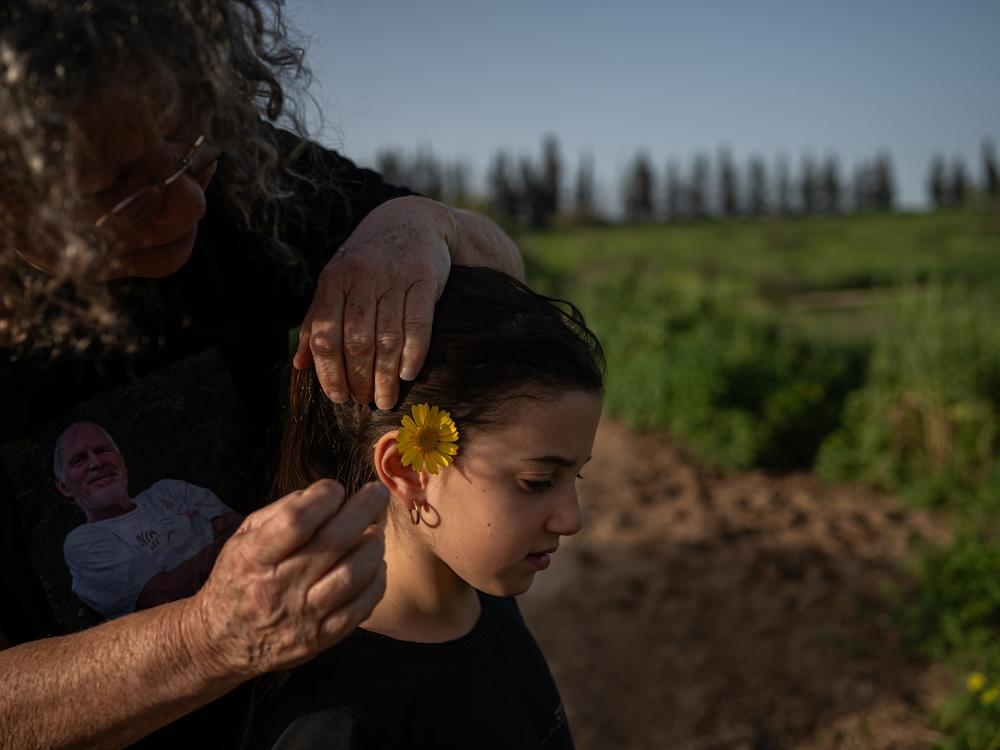Aviva Siegel, who was held hostage in Gaza for 51 days after the Hamas-led attack on Israel of Oct. 7, 2023, places a flower behind her eight-year-old granddaughter Yali Tiv's ear as they go for a walk near Kibbutz Gazit on March 26. <a href=