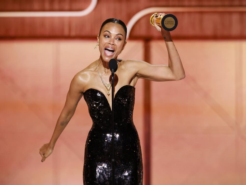 Zoe Saldaña accepts the award for best supporting actress in a motion picture at the Golden Globes Sunday night for her role in the film <em>Emilia Pérez. </em>