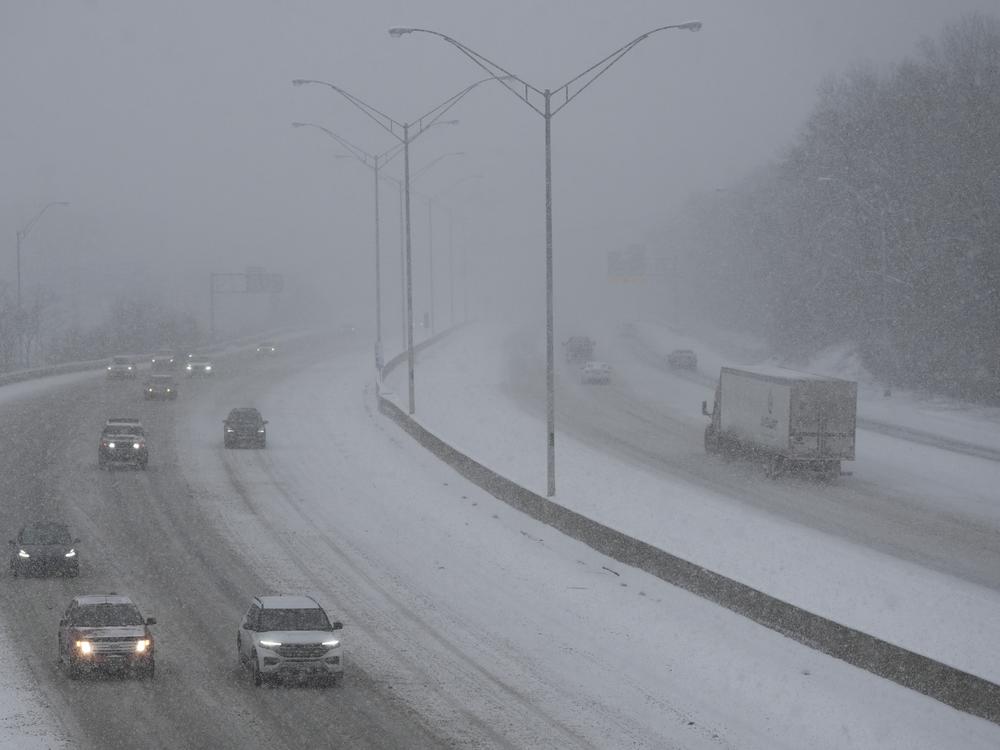 Vehicles drive along a highway during a winter storm, Sunday, Jan. 5, 2025, in Cincinnati.