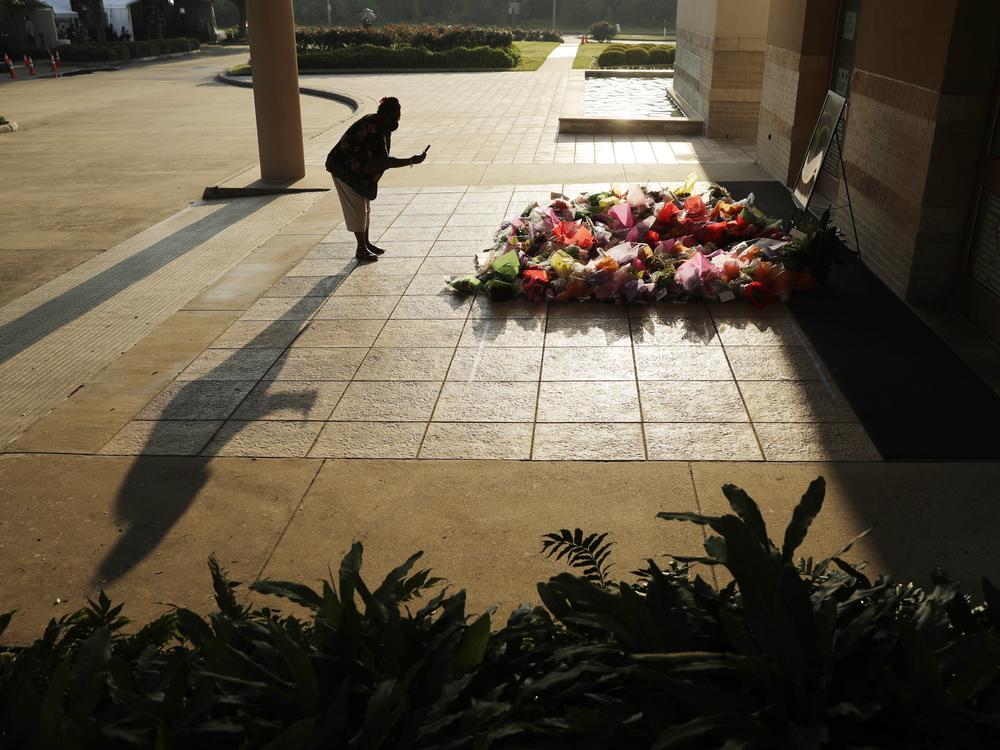 A woman stops to photograph a memorial for George Floyd at The Fountain of Praise church in Houston, June 9, 2020, in Houston.