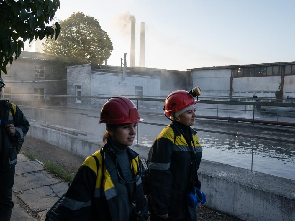 Tetiana Medvedenko (left) and Iryna Ostanko (right), both underground machine operators, walk to the elevators that will take them below the surface into a DTEK coal mine near Ternivka, Ukraine.