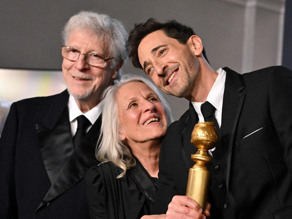 Adrien Brody (R) poses alongside his parents Sylvia Plachy (C) and Elliot Brody (L) in the press room during the 82nd annual Golden Globe Awards.