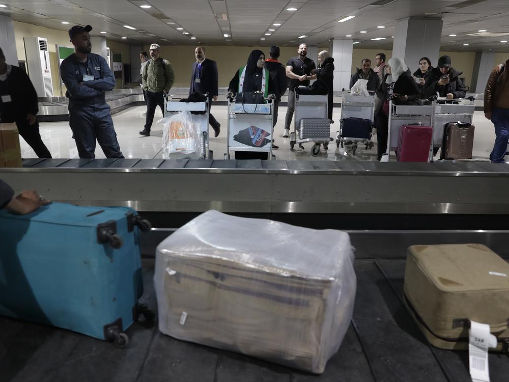 Passengers who arrived at a first international commercial flight since the fall of former Syrian President Bashar Assad, wait to receive their luggages at the arrival terminal of Damascus international airport, in Damascus, Syria on Tuesday.