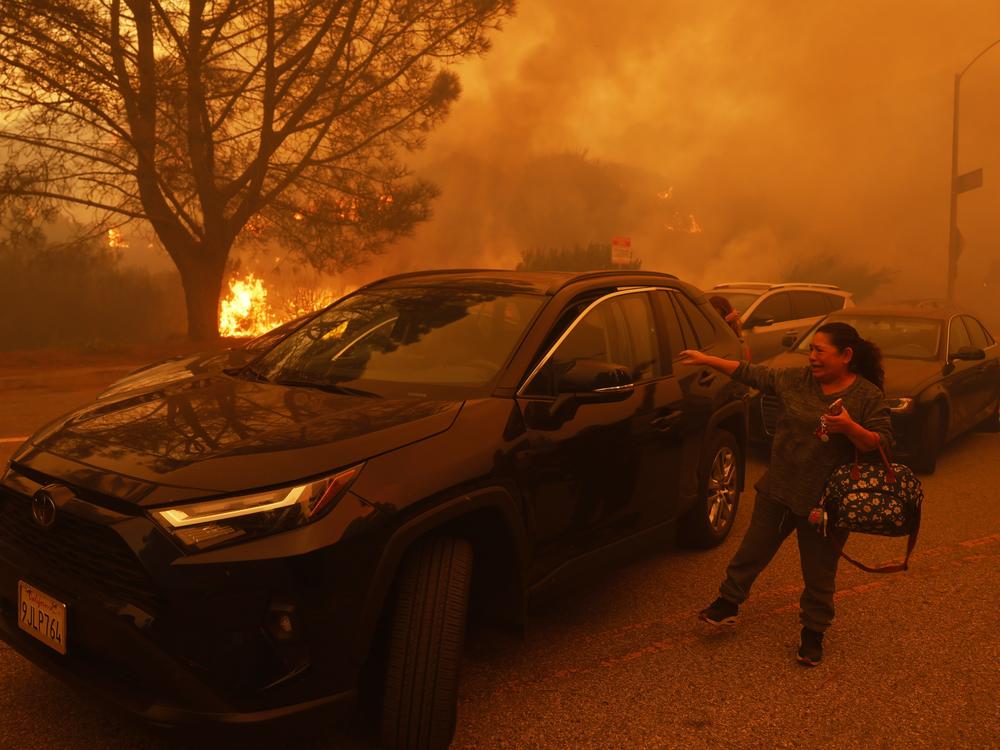 A woman cries as the Palisades Fire advances in the Pacific Palisades neighborhood of Los Angeles Tuesday, Jan. 7, 2025.