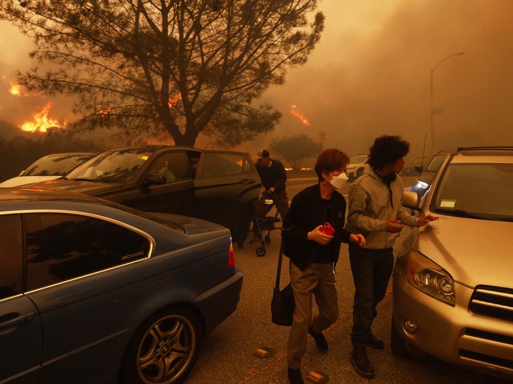 People flee from the advancing Palisades Fire, by car and on foot, in the Pacific Palisades neighborhood of Los Angeles.