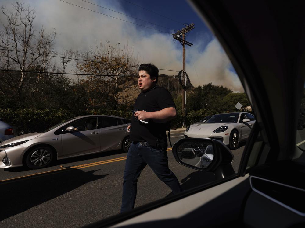 A person flees from an advancing wildfire in the Pacific Palisades neighborhood of Los Angeles.