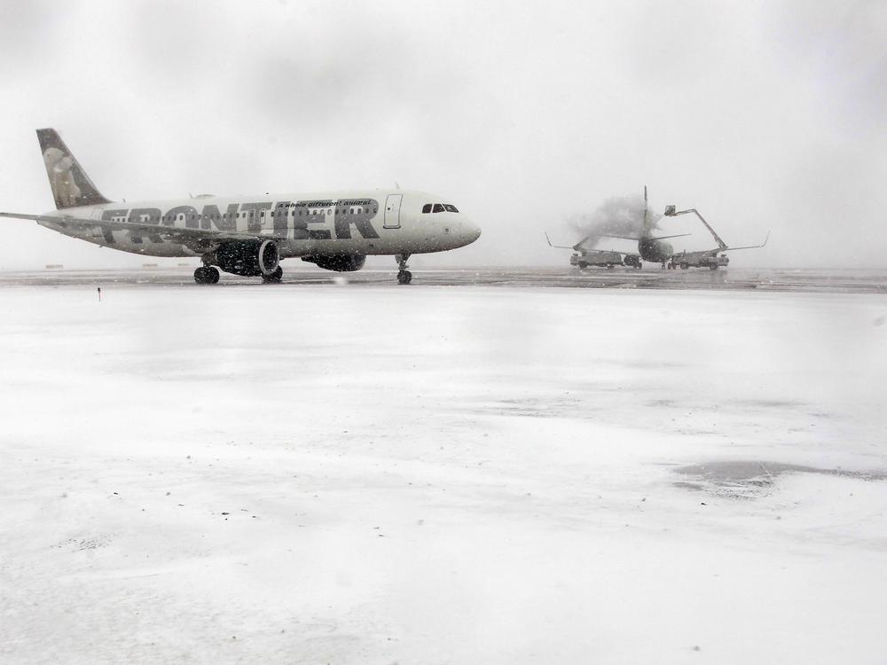 A Frontier Airlines plane approaches a de-icing station before takeoff in Denver in this file photo. Two powerful winter storms are disrupting the U.S. air travel system this week.
