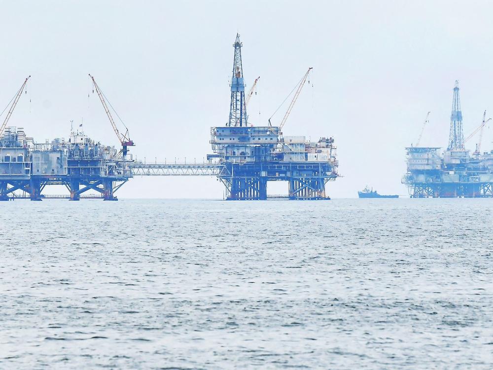 Three oil platforms are seen in federal waters off the southern California coast in 2021.  President Biden has prohibited new oil and gas leases in more than 625 million acres of federal ocean; existing leases are not affected.