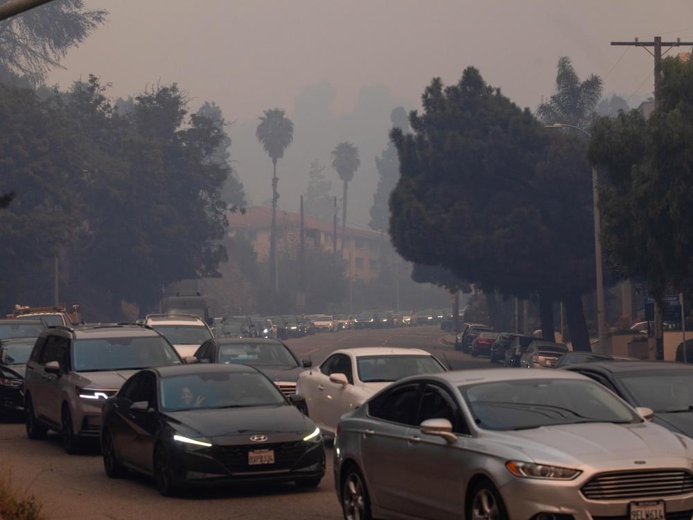 People evacuate on Sunset Boulevard from the Palisades Fire on Jan. 7, 2025 in the Pacific Palisades neighborhood of Los Angeles, Calif.