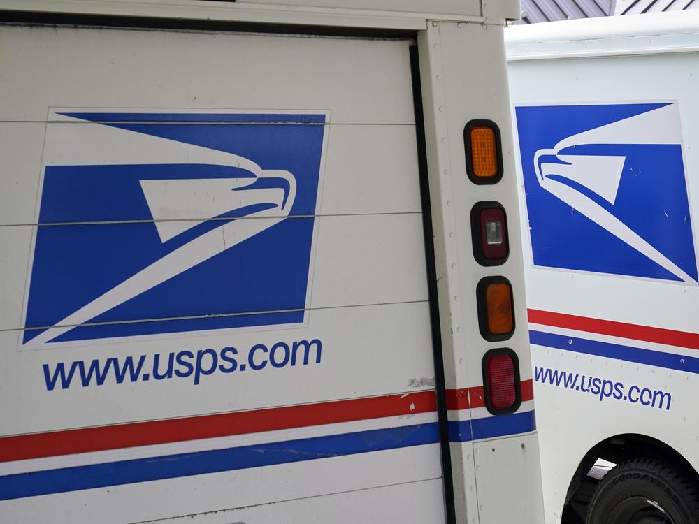 Mail delivery vehicles are parked outside a post office in Boys Town, Neb., in August 2020.