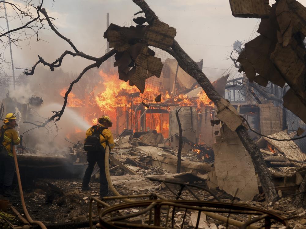 Wed., Jan. 8: Firefighters battle the Palisades Fire as it burns a structure in the Pacific Palisades neighborhood.
