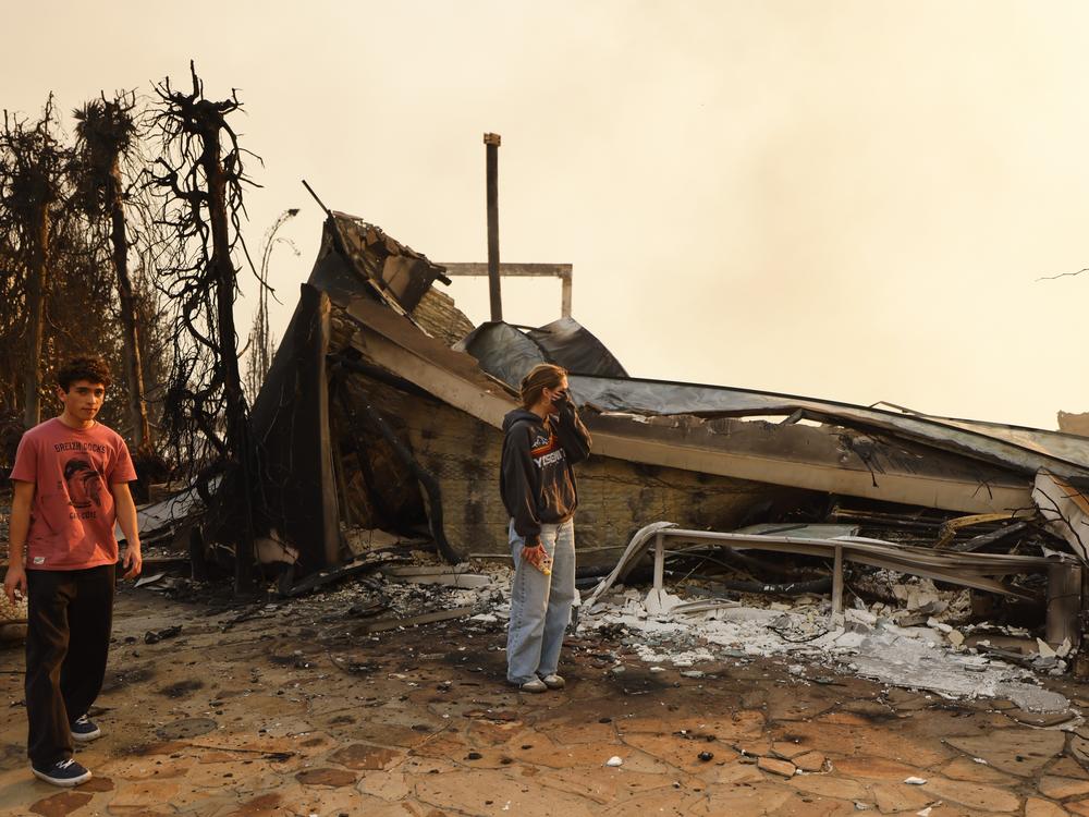 Wed., Jan. 8: Fallon Prockiw-Kline, center, gets emotional in front of her home which was damaged by the Palisades Fire, in Malibu, Calif.