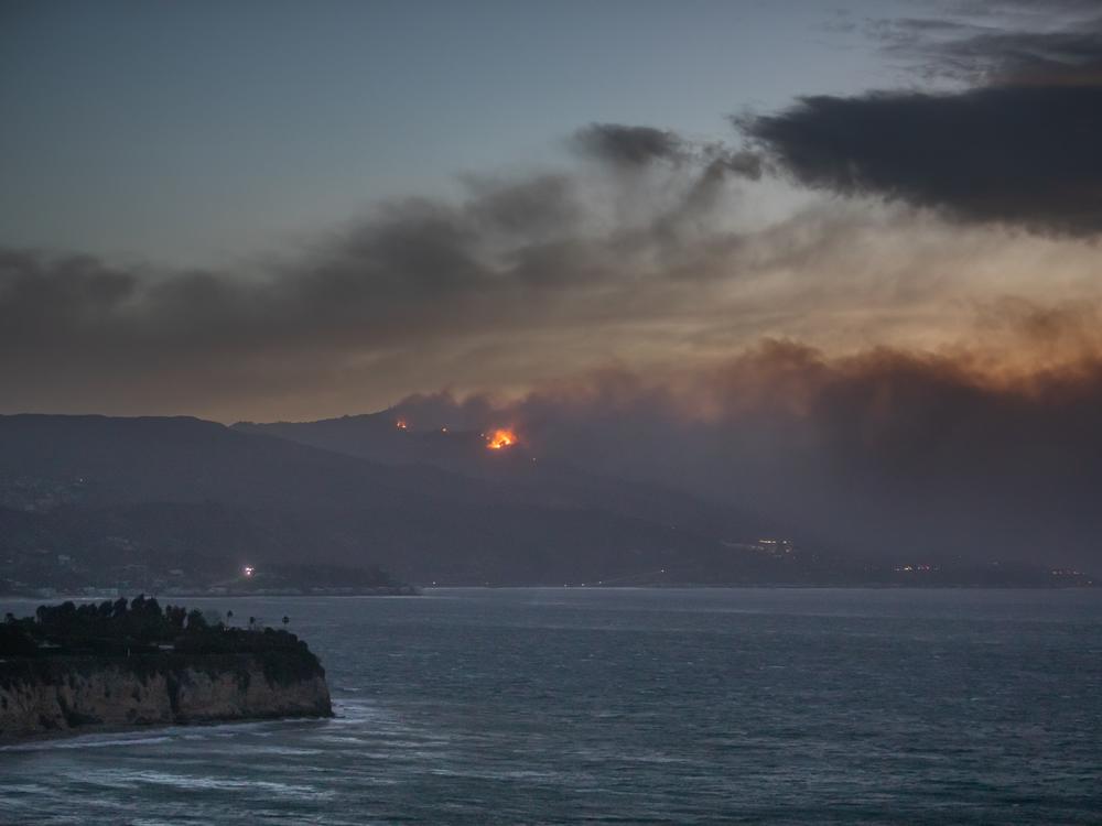 Smoke from the Palisades Fire is seen from Point Dume while it burns homes along the Pacific Coast Highway amid a powerful windstorm on Wednesday in Malibu, California. Fueled by intense Santa Ana winds, the Palisades Fire has burned through thousands of acres while a second major fire continues to burn near Eaton Canyon in Altadena.