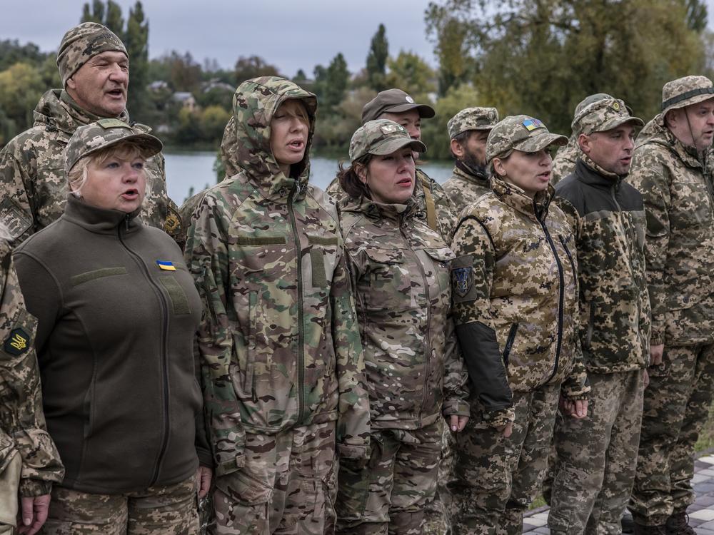 Members of the Combat Witches of Bucha, a nearly all-female air defense unit, join members of Bucha's territorial defense in a roll call before training in a forest outside Kyiv, Ukraine, on Oct. 12, 2024.