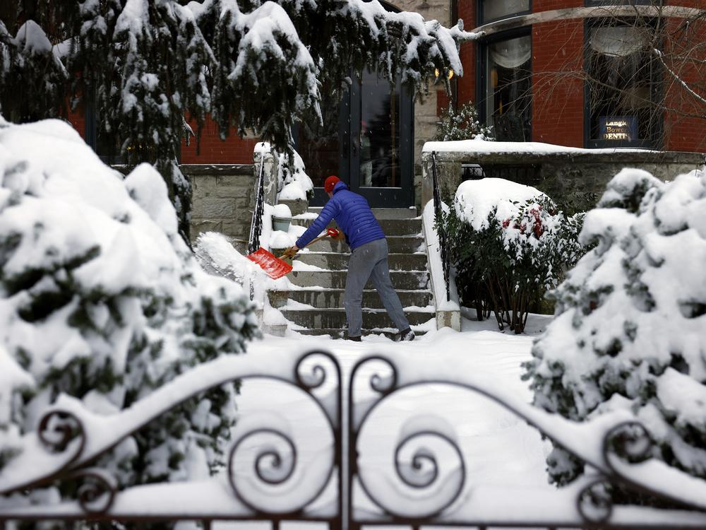 Langley Bowers shovels the snow off his stoop on Capitol Hill in Washington, D.C., on Jan. 6, 2024, as a major snow storm blanketed the city.