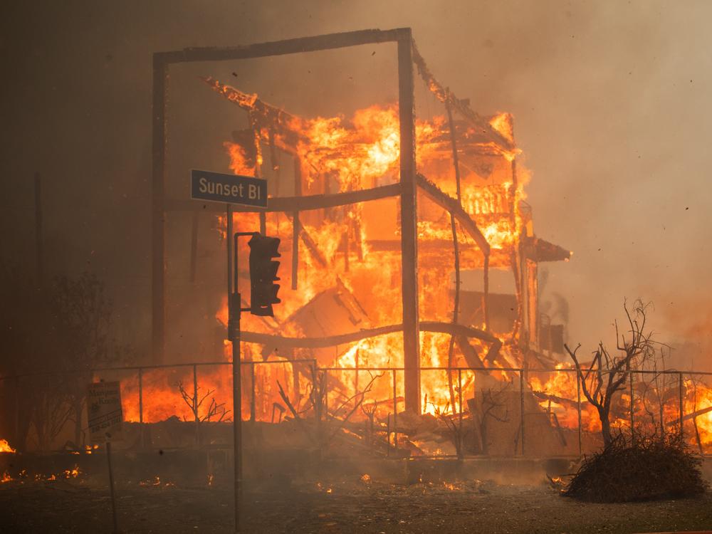 Flames from the Palisades Fire burn a building on Sunset Boulevard amid a powerful windstorm on Wednesday in the Pacific Palisades neighborhood of Los Angeles.