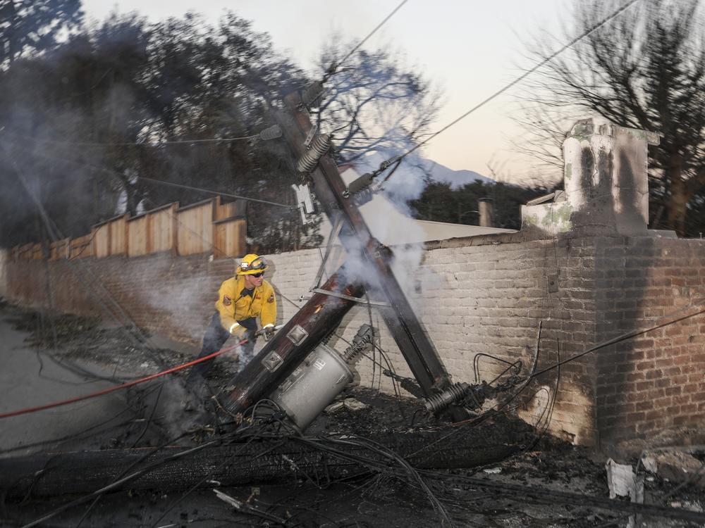 Friday, Jan. 10: Firefighter works to extinguish a still smoldering fire in Altadena.