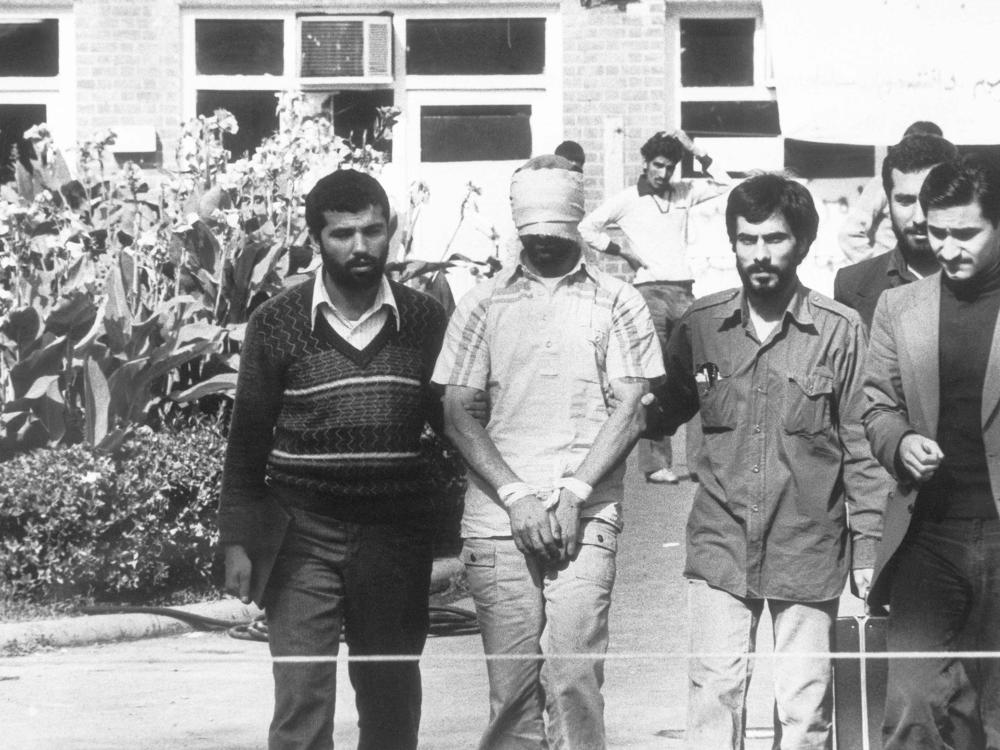 In this Nov. 8, 1979 file photo, one of the hostages held at the U.S. Embassy in Tehran, Iran, is shown to the crowd by Iranian students.