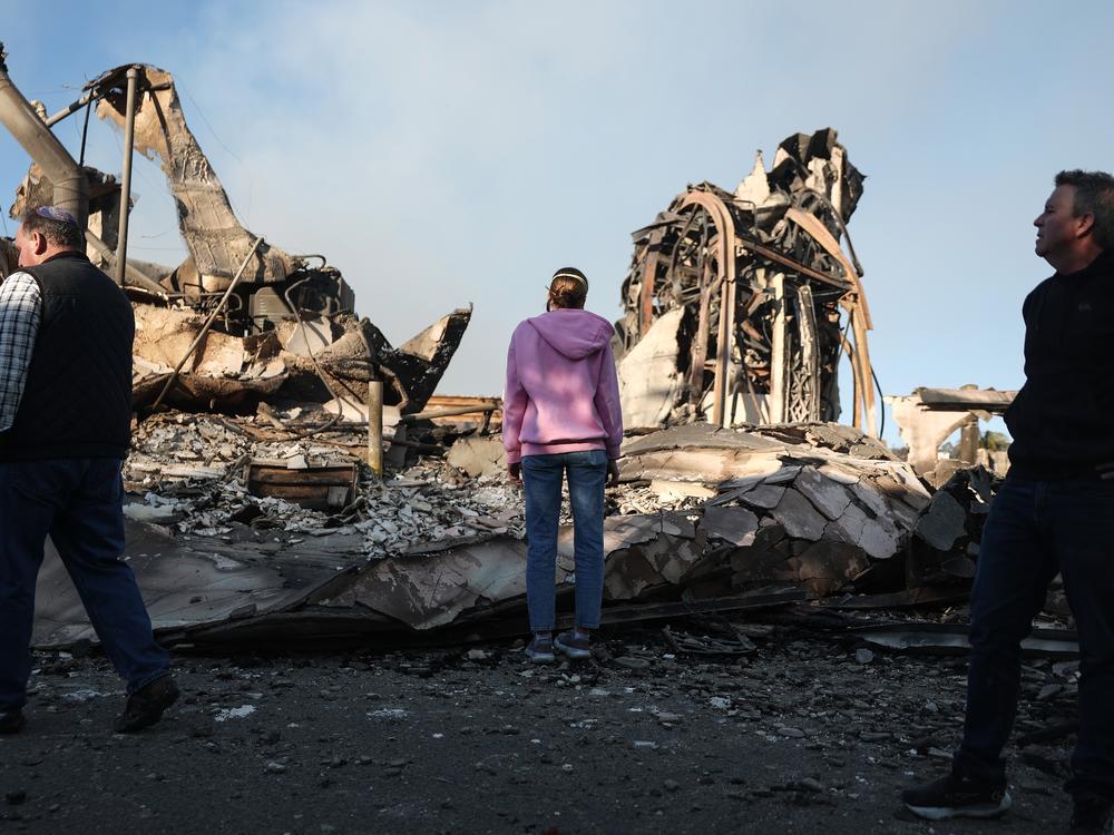 Friday, Jan. 10: Rev. John Shaver (R) looks on while visiting the remains of Community United Methodist Church, where he is pastor.