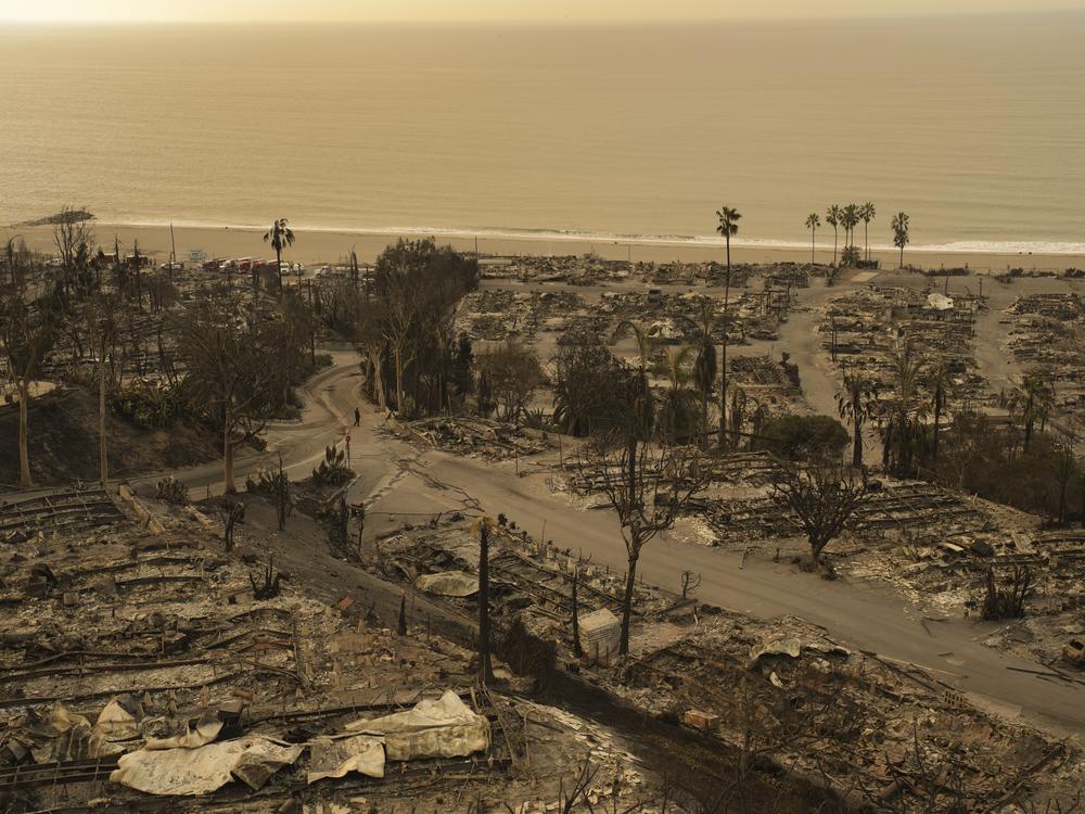 A person walks down a street in the aftermath of the Palisades Fire in the Pacific Palisades neighborhood of Los Angeles, on Saturday.