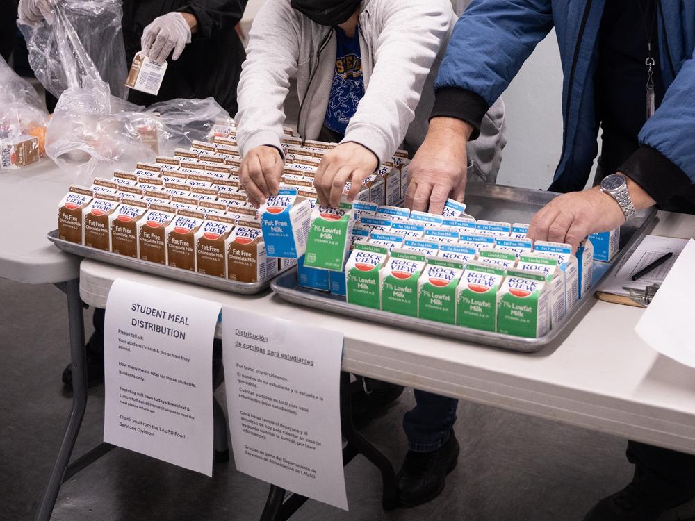 Workers assemble bags for families to pick up. Each one includes breakfast and lunch.