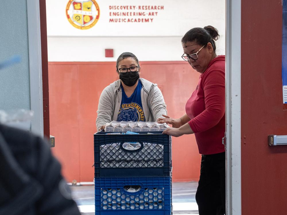 Crates of milk cartons are rolled through the halls of Hollenbeck Middle School. LAUSD is providing two meals per student, per day.