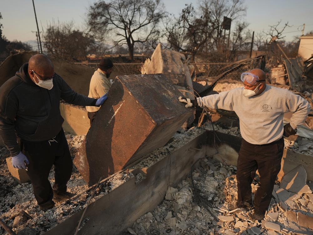Kenneth Snowden, left, surveys the damage to his fire-ravaged property with his brother Kim, center, and Ronnie in the aftermath of the Eaton Fire in Altadena, Calif. on Friday.