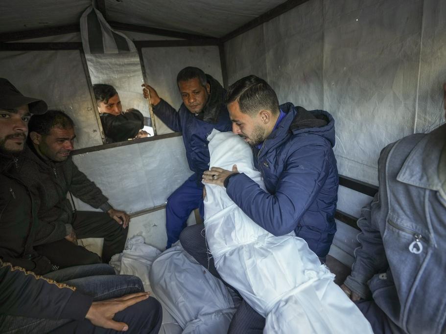 Mohammad Eid carries the body of one of his three relatives killed on Saturday in an Israeli airstrike, as they are prepared for the funeral in Deir al-Balah, central Gaza Strip, Sunday, Jan. 12, 2025. (AP Photo/Abdel Kareem Hana)