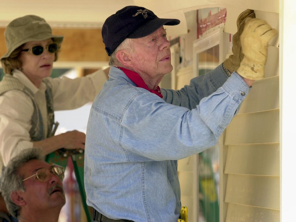 Former President Jimmy Carter and his wife, Rosalynn Carter, attach siding to the front of a Habitat for Humanity home being built on June 10, 2003, in LaGrange, Georgia.
