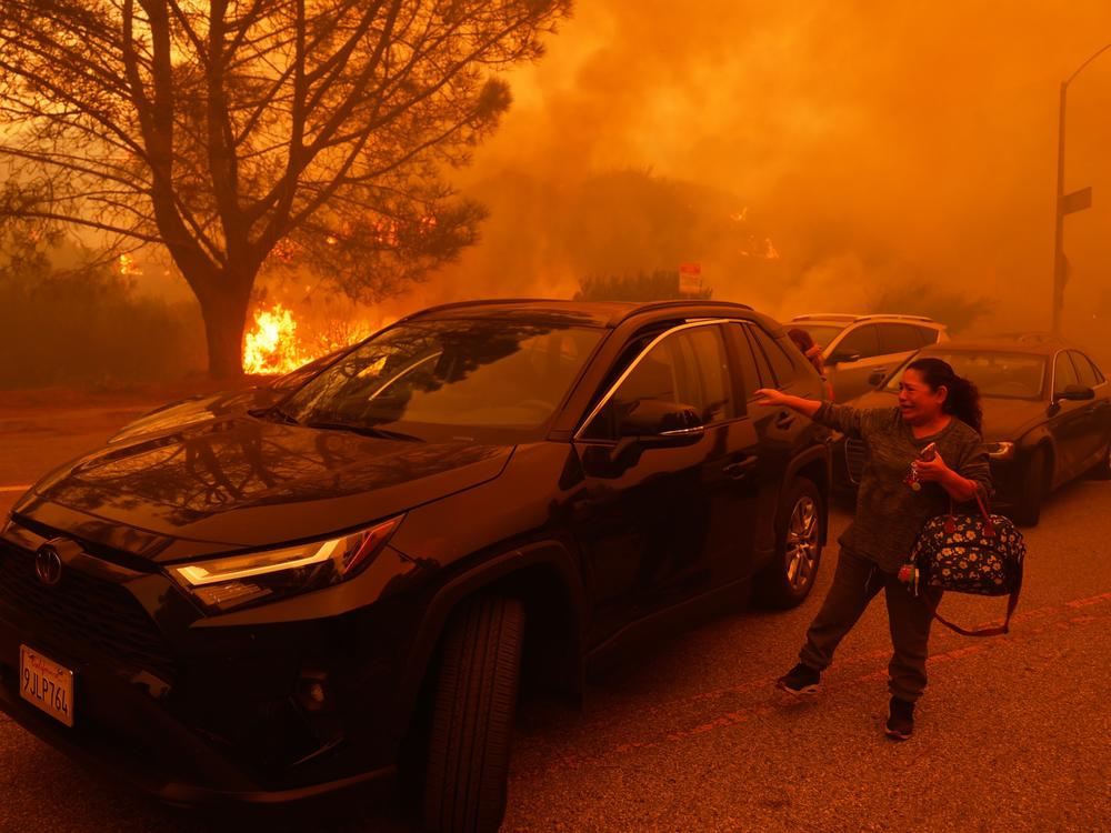 Tuesday, Jan. 7: A woman cries as flames advance in the Pacific Palisades neighborhood of Los Angeles.