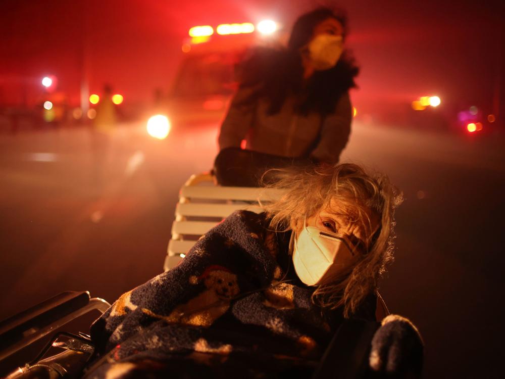 Tuesday, Jan. 7: A resident of a senior center is evacuated as the Eaton Fire approaches in Altadena, Calif.