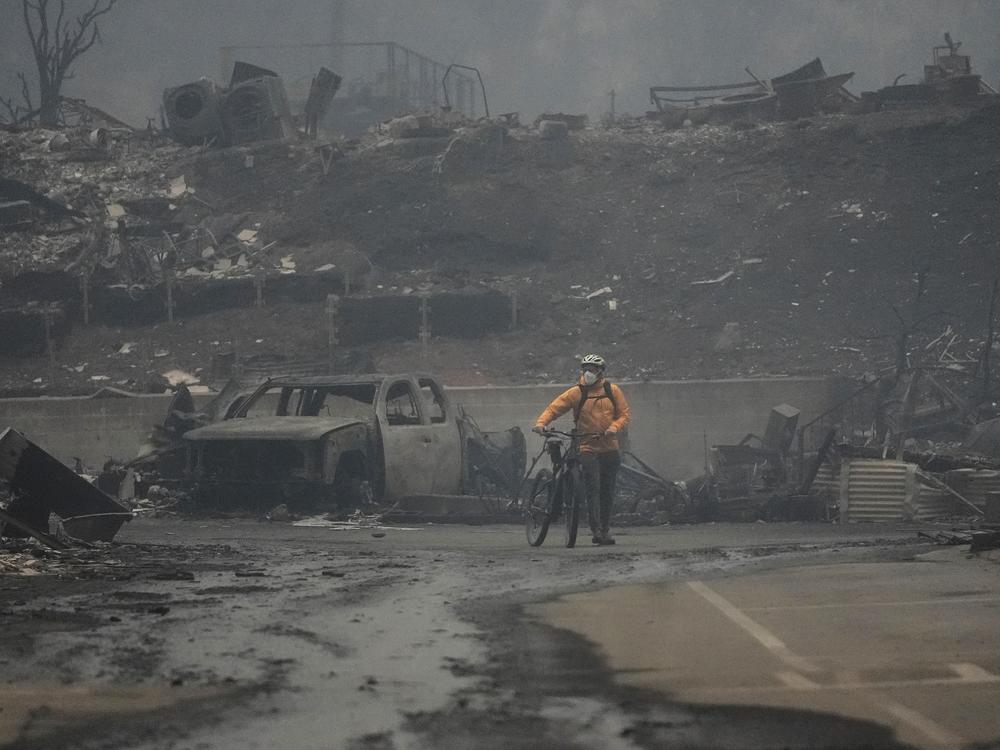 Wednesday, Jan. 8: A man walks his bike among the ruins left behind by the Palisades Fire in Los Angeles.