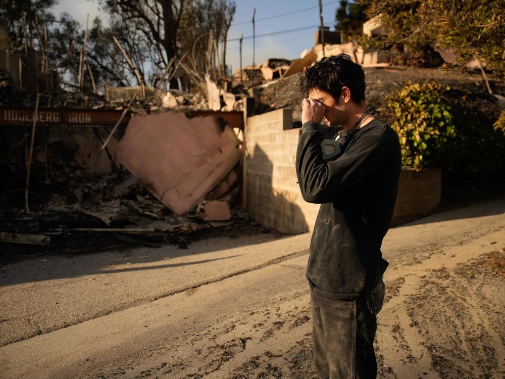 Saturday, Jan. 11: Oliver Braren wipes his eyes as he takes a moment from sifting through the fire-ravaged home of Kaegan Baron's mother in Los Angeles.