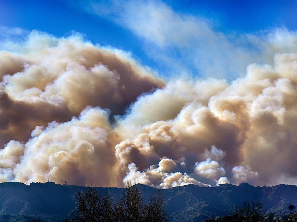 Saturday, Jan. 11: Smoke from the Palisades Fire rises over a ridge as seen from the Encino section of Los Angeles.