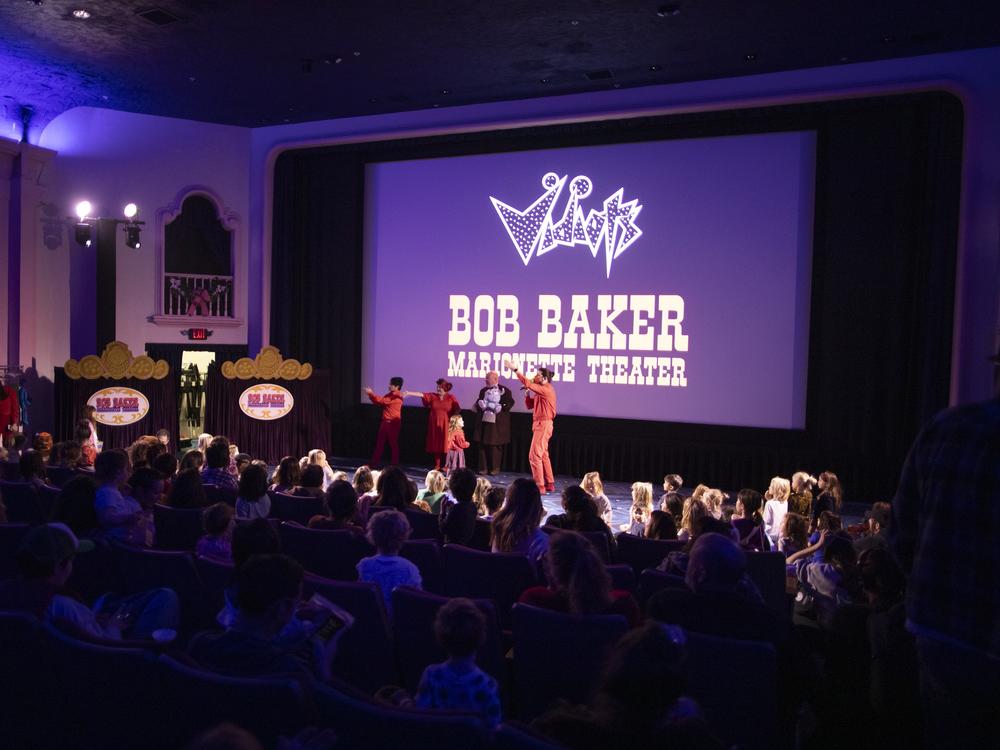 Performers with the Bob Baker Marionette Theater gesture to the crowd of families at Vidiots, a historic theater in northeast Los Angeles, a few miles from where fires are still burning in the Altadena and Pasadena neighborhoods.