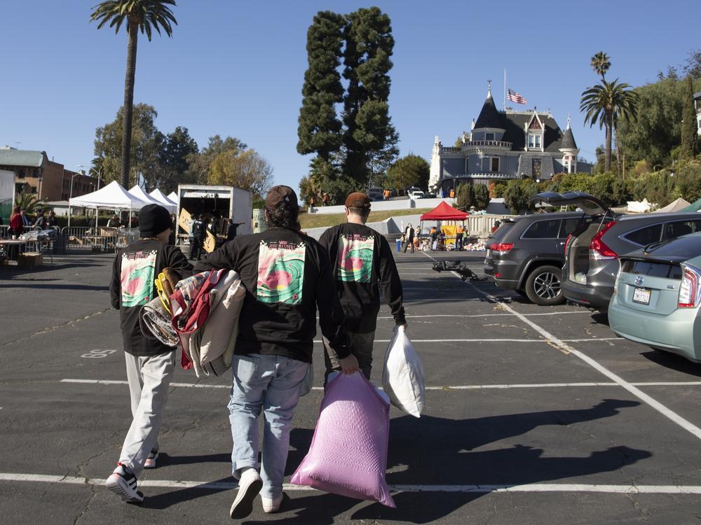 People visit the Magic Castle parking lot in Los Angeles, which has been turned into a donation pick-up and drop off center to help support tens of thousands of wildfire evacuees and victims across the county.