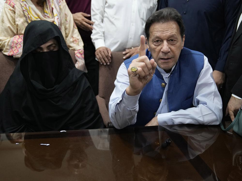 Pakistan's former Prime Minister Imran Khan, right, with his wife Bushra Bibi, speaks to the media before signing documents to submit surety bond over his bails in different cases, at an office of Lahore High Court in Lahore, Pakistan, on July 17, 2023.