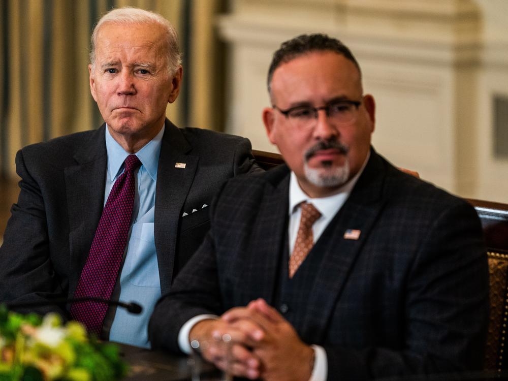 President Joe Biden pictured with his Department of Education secretary, Miguel Cardona, in October 2022.