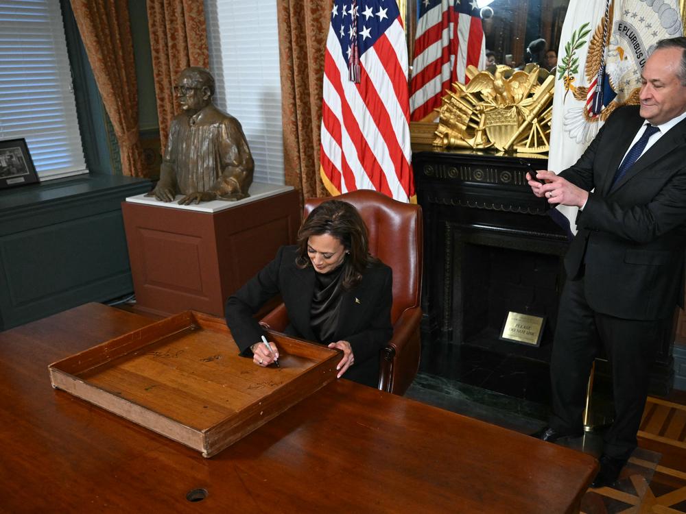 Vice President Harris signs the drawer of her desk as second gentleman Doug Emhoff takes a picture on Jan. 16, 2025.