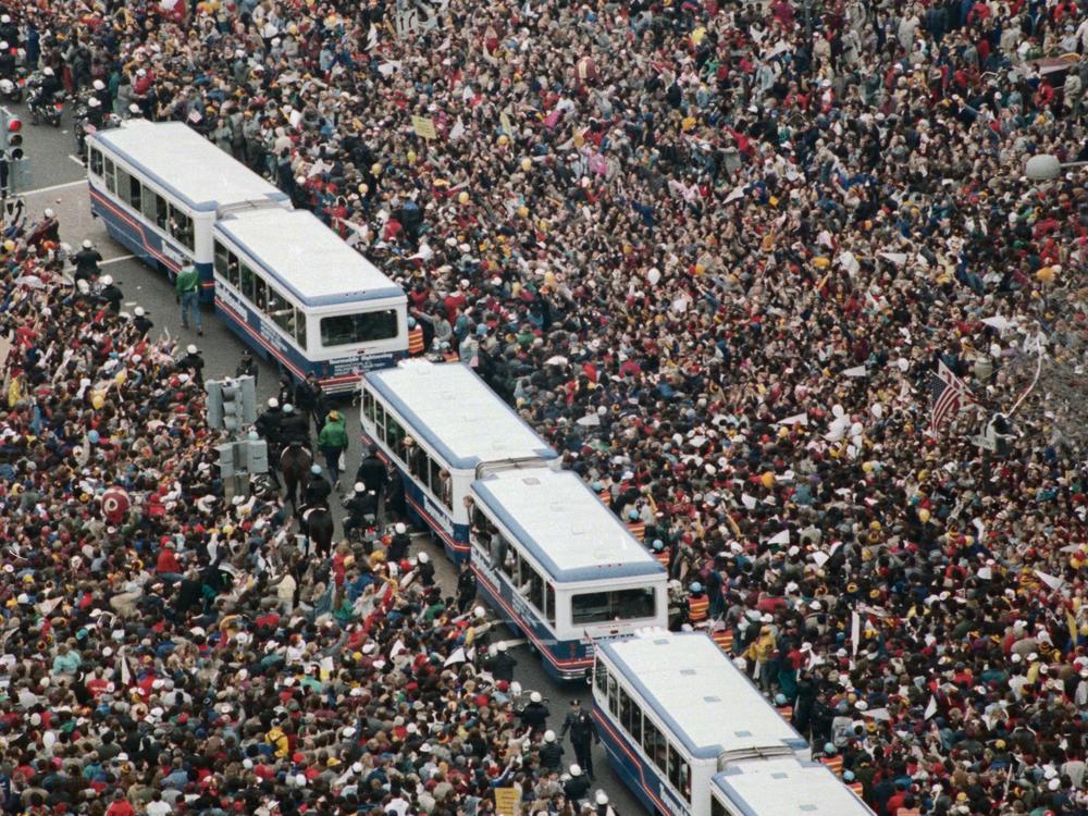 Buses carrying Washington Redskins football players wind through the crowd during the victory parade for the Super Bowl championship on Feb. 3, 1988.