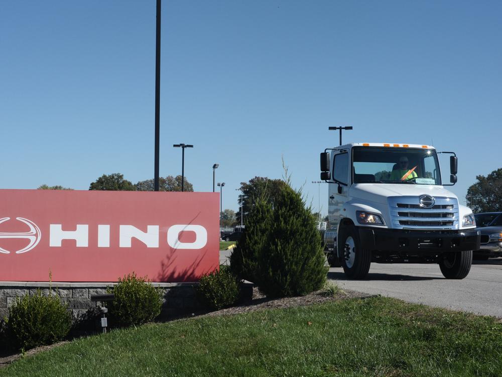 A truck passes a Hino sign in Williamstown, W.V., in 2017. The truck manufacturer, a Toyota subsidiary, has agreed to plea guilty to federal conspiracy charges and pay a total of $1.6 billion to settle civil claims after regulators discovered it was submitted fraudulent data to evade emissions standards.