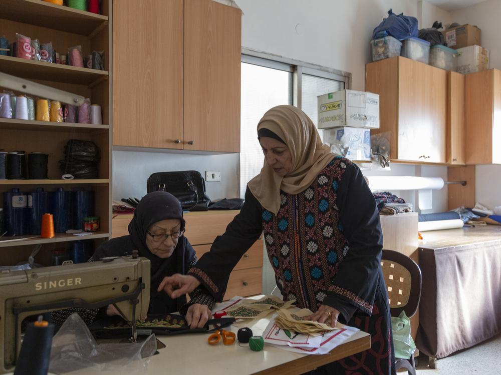 Hanan Zarura (right) gives instructions to an employee at her embroidery workshop in a Palestinian refugee camp in Beirut, Lebanon, on Dec. 2, 2024.