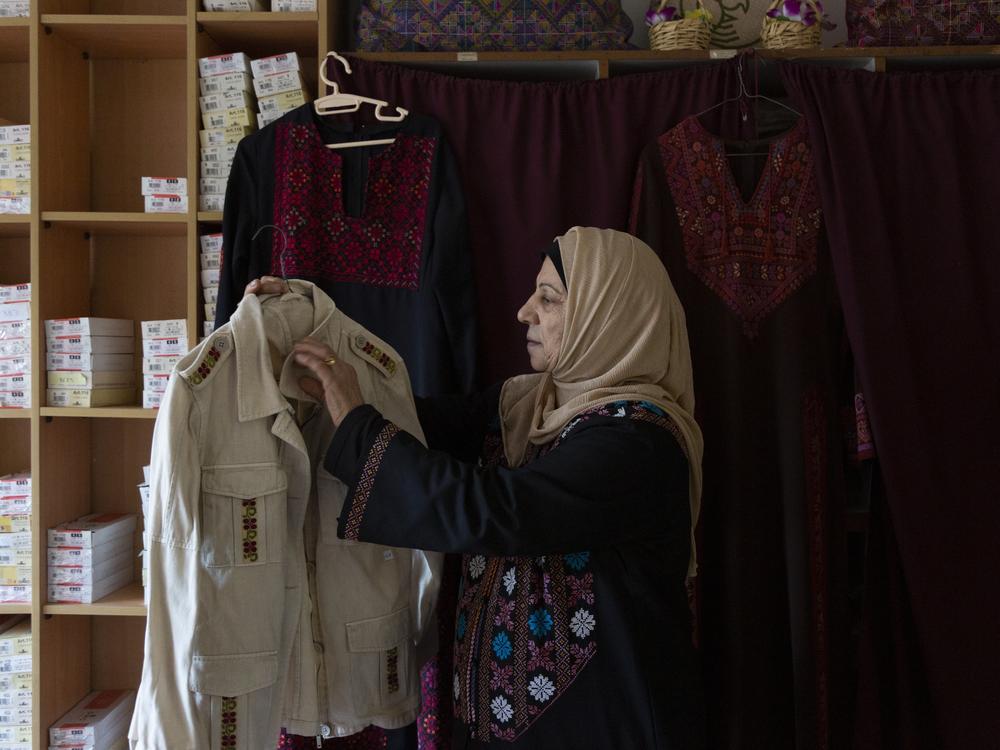 Hanan Zarura, a master craftswoman of Palestinian tatreez embroidery, with a jacket she's been making at her workshop in the Palestinian refugee camp of Shatila, in Beirut, Lebanon.