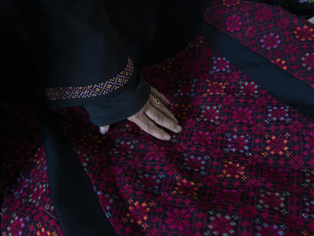 Hanan Zarura shows off a Palestinian embroidered thobe, a traditional garment worn in the Arab world.