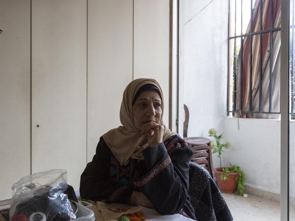 Hanan Zarura sits in an office adjacent to her embroidery workshop in the Palestinian refugee camp of Shatila, in Lebanon's capital.